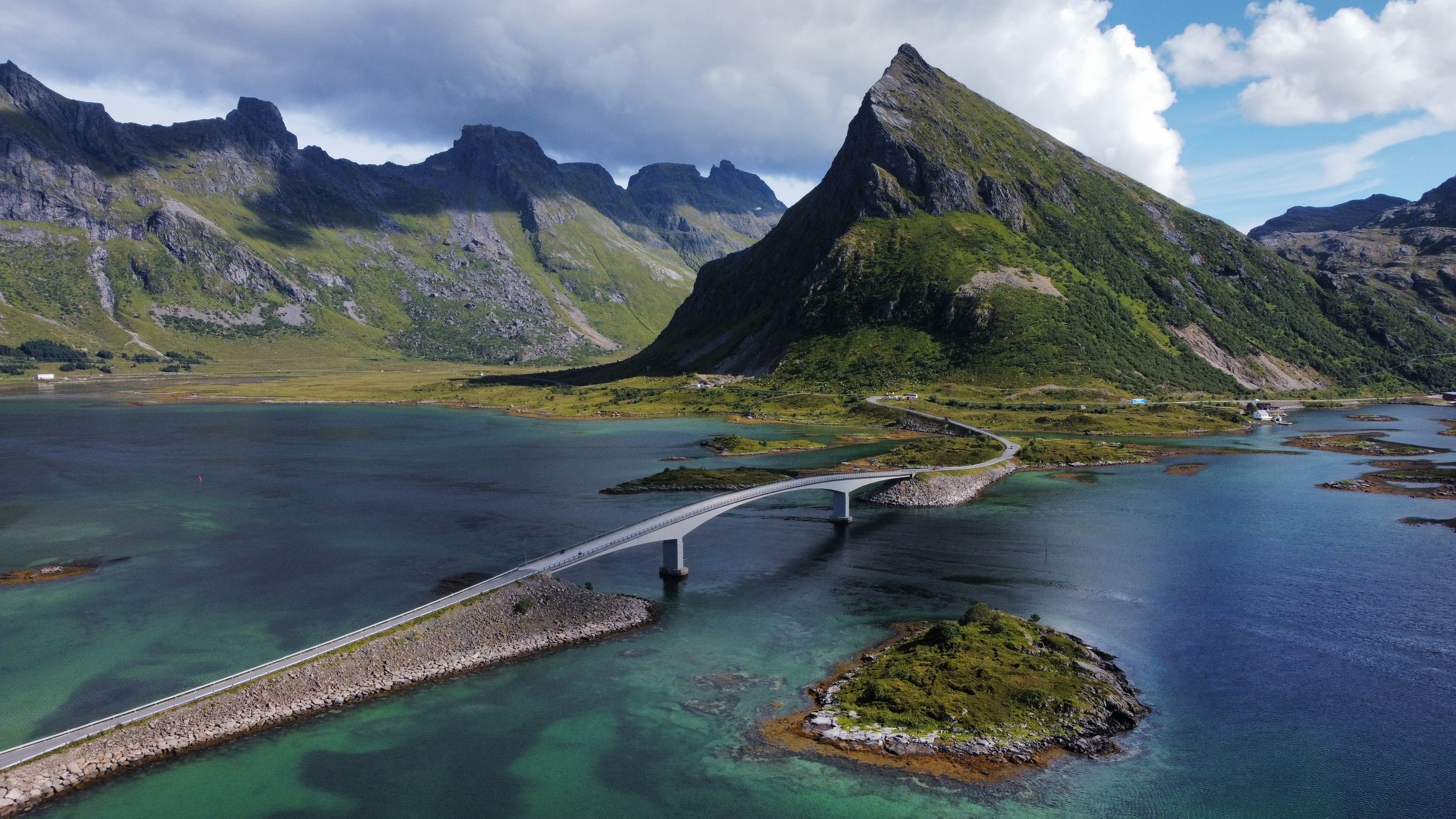Cime verdi e un ponte sull’acqua limpida della costa